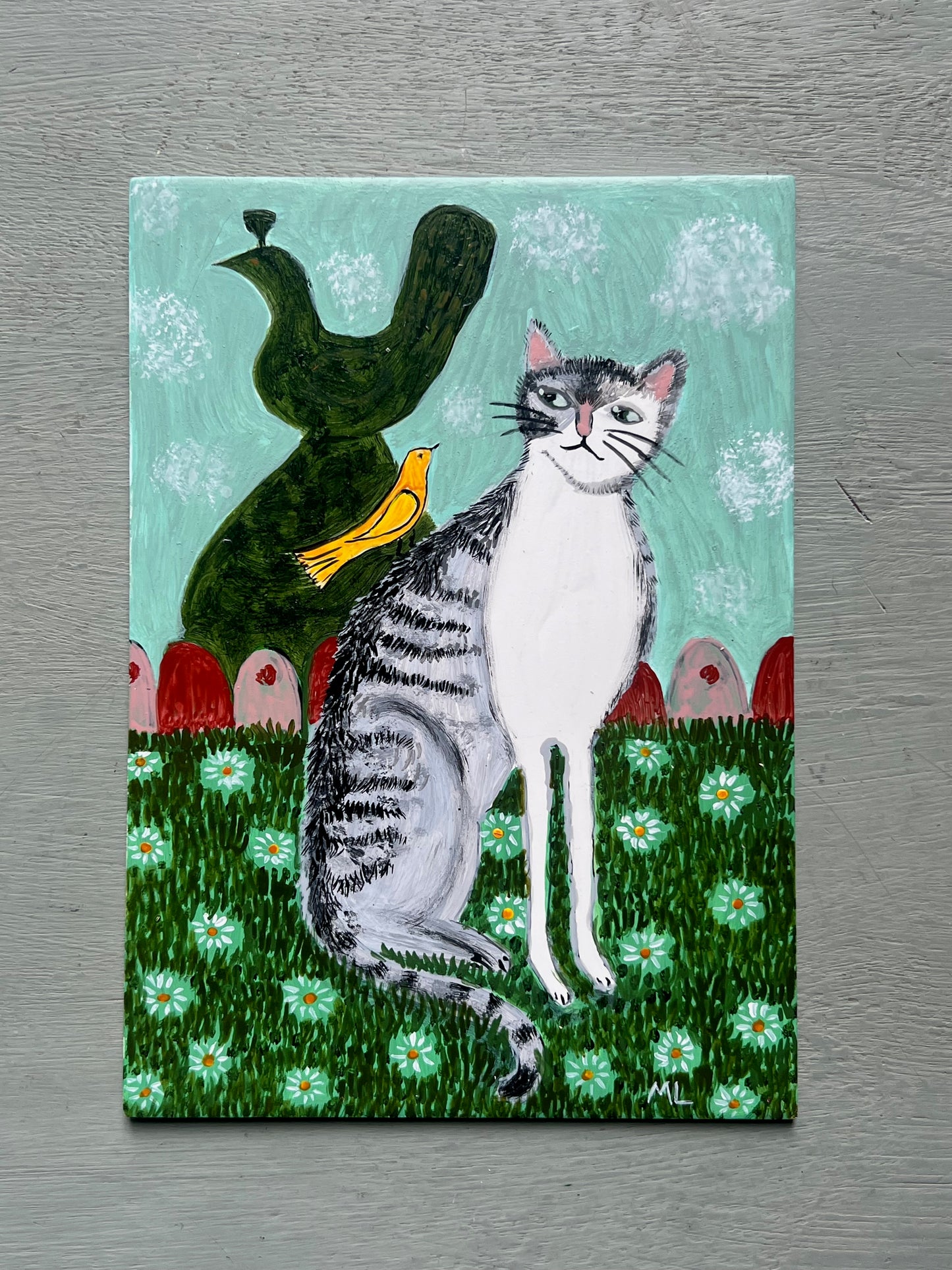 Original acrylic painting of a grey tabby cat sitting amongst white daisies beside a yellow bird and dark green ornamental figure against a pale turquoise background, painted on a 5 x 7 inch wooden board.